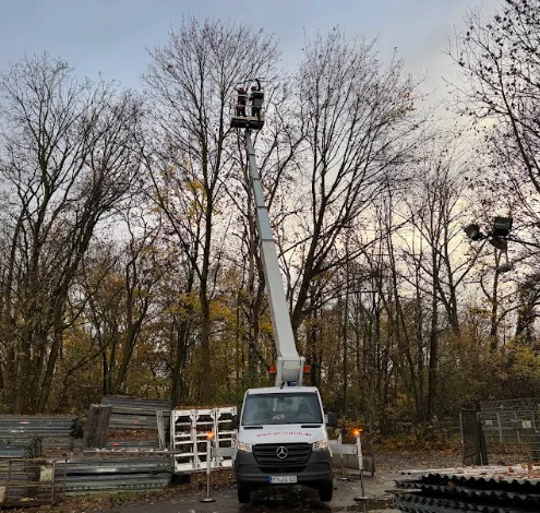 Baumarbeiten mit einer Arbeitsbühne an einem Grundstück